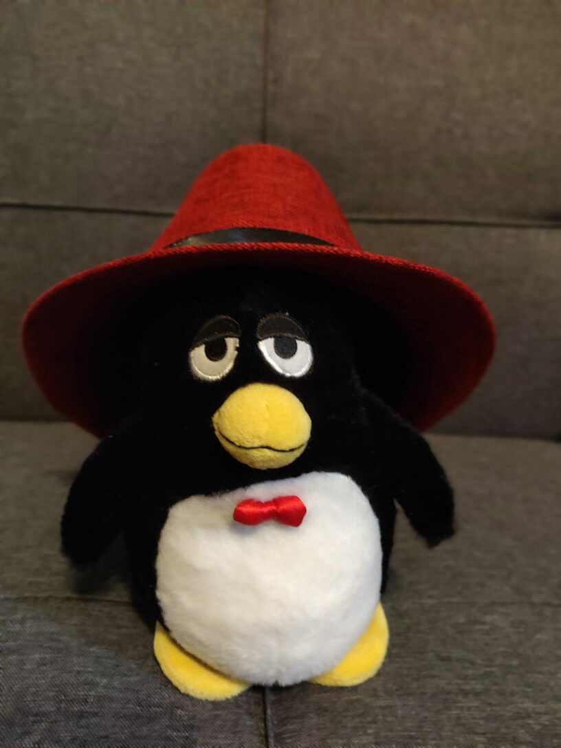 GNU Linux penguin with Red Hat Fedora on